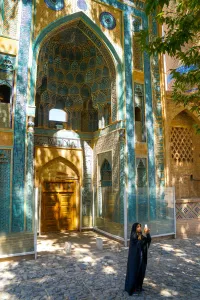 Headscarf Prints: Young Iranian girl in chador taking picture in front of Jameh Mosque, Natanz, Iran