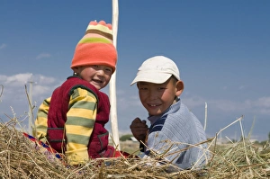 Two young kids on a carrier loaded with hay, Torugat Pass, Kyrgyzstan, Central Asia, Asia Two young kids on a carrier loaded with hay, Torugat Pass, Kyrgyzstan, Central Asia, Asia