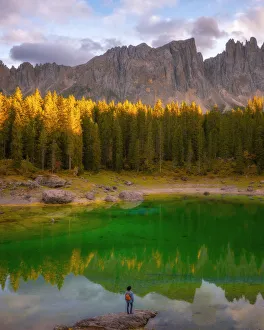 Backpack Prints: Young man observing the beauty of Lago Di Carezza at sunset, Dolomites, Italy, Europe