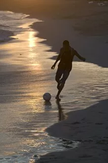 Young man playing football at sandbeach in twilight, Santa Maria, Sal, Cape Verde, Africa
