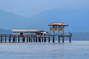 Fishing Rod Prints: Young men fishing from a local building on Bangka Island