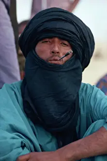 One Man Only Prints: Young Tuareg man smoking small pipe and wearing headscarf