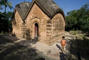 Restored Prints: Young village girl beside restored miniature terracotta Hindu temple to Shiva