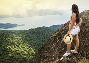 Young woman looking out over the Green Coast (Costa Verde) from Papapagaio peak
