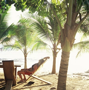 Bare Foot Prints: Young woman relaxes on Avellans Beach, Costa Rica, Central America
