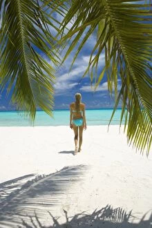 Young woman walking on beach, Maldives, Indian Ocean, Asia