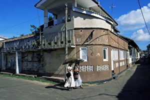 Sinelese Prints: Young women walking round a corner on a street in Galle