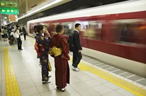 Young women wearing kimono waiting for train to arrive